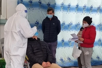 Người dân xếp hàng chờ xét nghiệm và lấy giấy xác nhận F0 tại trạm y tế phường tại Hà Nội. Ảnh: Mỹ Hà