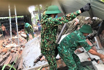Cán bộ, chiến sĩ Đồn Biên phòng Ea H’leo giúp người dân xã biên giới Ia Lốp sửa chữa nhà cửa bị hư hỏng do dông lốc.