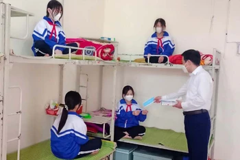 Giáo viên Trường phổ thông dân tộc nội trú huyện Na Rì phát khẩu trang cho học sinh.