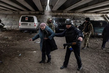Quân nhân Ukraine hỗ trợ cụ bà tại khu vực Irpin, gần thủ đô Kiev, di dời đến nơi an toàn, ngày 13/3. (Ảnh: Reuters)
