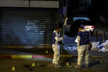 Chuyên gia pháp y của cảnh sát Israel làm việc tại hiện trường vụ tấn công tại Hadera, ngày 27/3. (Ảnh: Reuters)