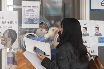 Nhân viên y tế lấy mẫu xét nghiệm Covid-19 cho người dân tại Seoul, Hàn Quốc. (Ảnh: THX/ TTXVN)