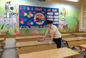 Giáo viên Trường Tiểu học Trần Quốc Toản (Hoàn Kiếm) vệ sinh lớp học chuẩn bị đón học sinh quay trở lại trường. (Ảnh: Đăng Anh)