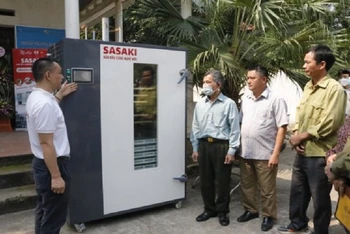 Các đại biểu tham quan máy sấy lạnh đa năng chuẩn bị cho việc sơ chế vải thiều xuất khẩu.