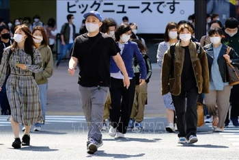 Người dân đeo khẩu trang phòng dịch COVID-19 tại Tokyo, Nhật Bản ngày 18/4/2021. Ảnh: AFP/TTXVN