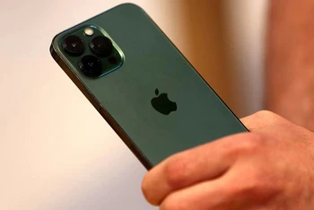 Một khách hàng cầm trên tay chiếc điện thoại iPhone 13 Pro màu xanh lục mới ngay sau khi nó được bày bán bên trong Apple Store tại Đại lộ số 5 ở Manhattan, New York City, tiểu bang New York, Mỹ, ngày 18/3/2022. (Ảnh: Reuters)
