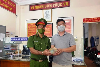 Đại úy Nguyễn Đức Dũng trao trả 300 triệu đồng cho người đánh rơi.