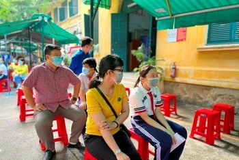Phụ huynh và trẻ chờ đến lượt tiêm tại điểm trường THCS Hồng Bàng.