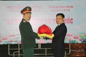 Thiếu tướng Bùi Hải Sơn, Tư lệnh, Bộ Tư lệnh Bảo vệ Lăng Chủ tịch Hồ Chí Minh trao tặng cờ Tổ quốc cho Đảng bộ, chính quyền và nhân dân huyện đảo Cô Tô (Quảng Ninh). (Ảnh: Hoàng Phương)