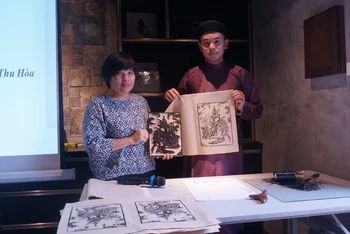 Nhà nghiên cứu Nguyễn Thị Thu Hòa (trái) cùng nghệ nhân Nam Chi giới thiệu kỹ thuật in một số bức tranh đồ thế.