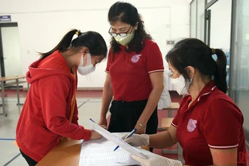 Làm thủ tục chuẩn bị tiêm cho học sinh tại Hà Nội. (Ảnh: DUY LINH)
