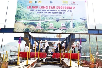 Lãnh đạo tỉnh Lào Cai, chủ đầu tư và đơn vị thi công thực hiện nghi thức hợp long cầu Suối Đum 2 trên cao tốc Lào Cai-Sa Pa.