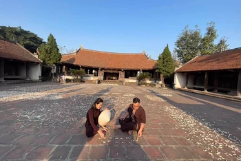 Khách du lịch trải nghiệm các di sản tại làng cổ Đường Lâm.