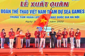 Trưởng đoàn thể thao Việt Nam dự SEA Games 31 Trần Đức Phấn nhận lá cờ Tổ quốc từ Phó Thủ tướng Thường trực Chính phủ Phạm Bình Minh. (Ảnh: THỦY NGUYÊN)