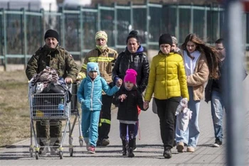 Người dân Ukraine sơ tán tránh chiến sự tới cửa khẩu Medyka, giáp giới Ba Lan ngày 27/3/2022. (Ảnh: AFP/TTXVN)