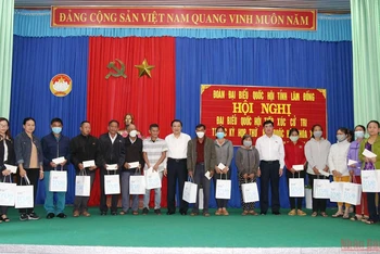 Đồng chí Phan Đình Trạc và đồng chí Trần Đình Văn trao quà tặng các gia đình chính sách, gia đình có hoàn cảnh khó khăn xã Tân Hội. 