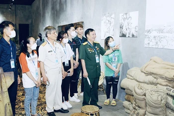 Các cựu chiến binh, các em học sinh tham quan triển lãm.
