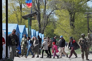 Người dân rời khu vực gần nhà máy thép Azovstal ở Mariupol đi cùng các nhân viên Liên hợp quốc tại 1 trung tâm lưu trú tạm thời ở làng Bezimenne thuộc Donetsk, Ukraine, ngày 1/5/2022. (Ảnh: Reuters)