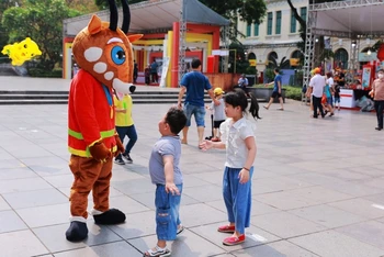 Du khách nhí tương tác với chú sao la-linh vật của SEA Games 31 tại Lễ hội quà tặng du lịch Hà Nội 2022.