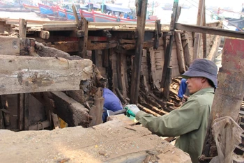 Người lao động ở xã Ngư Lộc, huyện Hậu Lộc tháo dỡ cấu kiện con tàu giải bản.