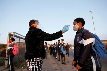 Kiểm tra thân nhiệt các học sinh trước khi vào lớp học ở thị trấn Langa, Cape Town, Nam Phi. (Ảnh: Reuters)