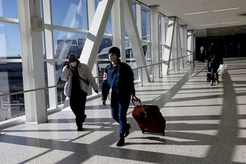 Hành khách đeo khẩu trang di chuyển tại sân bay quốc tế JFK ở New York, Mỹ, ngày 16/11/2021. (Ảnh: Reuters)