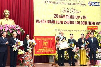 Đồng chí Nguyễn Văn Nên, Ủy viên Bộ Chính trị, Bí thư Thành ủy Thành phố Hồ Chí Minh (bên trái) trao Huân chương Lao động hạng Nhì cho tập thể Viện nghiên cứu phát triển Phương Đông.