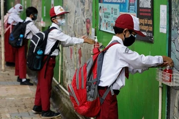 Học sinh tiểu học sát khuẩn tay sau khi tan học ở Jakarta, Indonesia, ngày 30/8/2021. (Ảnh minh họa: Reuters)