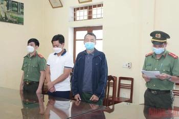 Cơ quan An ninh điều tra đọc lệnh bắt tạm giam đối tượng Khánh và An. (Ảnh: TTXVN)