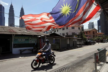 Người đàn ông đeo khẩu trang khi tham gia giao thông tại Kuala Lumpur trong thời gian thành phố này bị phong tỏa để chống Covid-19, ngày 2/2/2021. (Ảnh: Reuters)