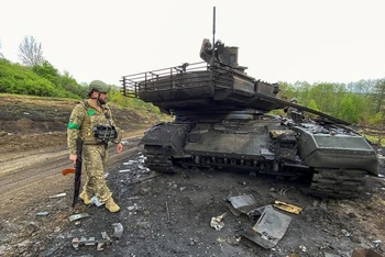 Binh sĩ Ukraine cạnh 1 xe tăng bị phá hủy gần làng Staryi Saltiv ở Kharkov, Ukraine ngày 9/5/2022. (Ảnh: Reuters)