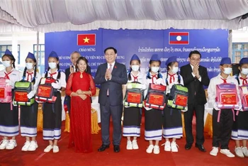 Chủ tịch Quốc hội Vương Đình Huệ tặng quà cho các cháu học sinh giỏi tại Trường phổ thông Dân tộc nội trú tỉnh Champasak (Lào), chiều 17/5. (Ảnh: TTXVN)