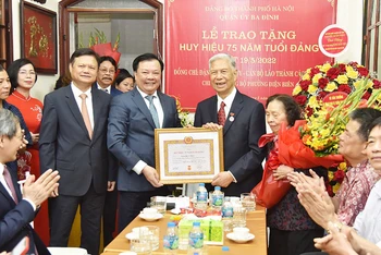 Bí thư Thành ủy Hà Nội Đinh Tiến Dũng trao Huy hiệu 75 năm tuổi Đảng cho Trung tướng Đặng Quân Thụy. (Ảnh: DUY LINH)