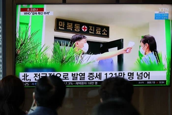 Từ một nhà ga của Hàn Quốc, người dân theo dõi bản tin về tình hình dịch Covid-19 tại Triều Tiên. (Ảnh: Reuters)