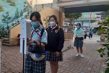 Học sinh Trường trung học cơ sở Lý Phong, quận 5, Thành phố Hồ Chí Minh kiểm tra thân nhiệt, sát khuẩn tay trước khi vào học (thời điểm dịch Covid-19 đang diễn ra phức tạp).