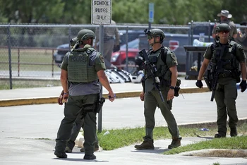 Lực lượng thực thi pháp luật đứng bên ngoài Trường tiểu học Robb sau vụ nổ súng ngày 24/5. (Ảnh: AP)