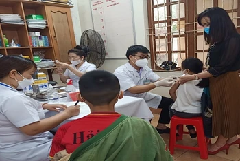 Trẻ dưới 12 tuổi ở Thái Bình có tâm thế khá thoải mái khi thực hiện tiêm vaccine ngừa Covid-19.