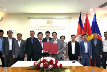 Đại sứ Nguyễn Huy Tăng và ông Phùng Văn Cường, Tổng Giám đốc Công ty Viettel Cambodia Pte.Ltd ký kết thỏa thuận. (Ảnh: Nguyễn Hiệp)