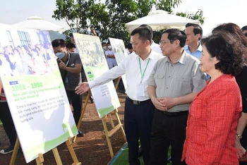 Thủ tướng Phạm Minh Chính xem sản phẩm nông nghiệp tại Lễ khởi công dự án “Tổ hợp thiên đường sữa Mộc Châu”. 
