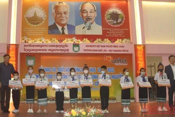Đại sứ Việt Nam Nguyễn Bá Hùng cùng các học sinh Trường song ngữ Lào-Việt Nam Nguyễn Du tại buổi lễ. (Ảnh: Cộng tác viên)