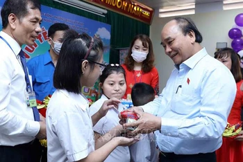 Chủ tịch nước tặng quà cho trẻ khuyết tật. (Ảnh: TTXVN)
