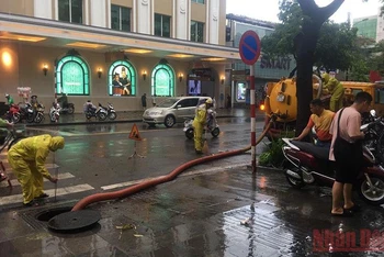 Công nhân Công ty Thoát nước Hà Nội khơi thông cống ngầm để tăng cường thoát nước trên phố Hai Bà Trưng, quận Hoàn Kiếm, Hà Nội.