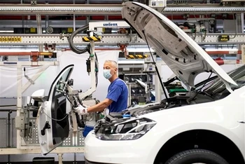 Công nhân làm việc trên dây chuyền lắp ráp ô-tô của hãng Volkswagen ở Wolfsburg (Đức). (Ảnh: Reuters/TTXVN)