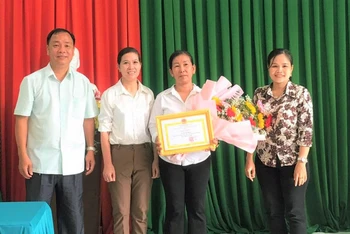 Lãnh đạo Ủy ban nhân dân thành phố Long Khánh tặng Giấy khen cho chị Phụng.