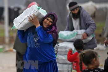Người tị nạn Syria nhận hàng viện trợ. (Ảnh: AFP/TTXVN)