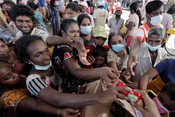 Người dân Sri Lanka nhận hàng hóa viện trợ. (Ảnh: Reuters/TTXVN)