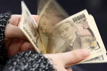 Người phụ nữ đang đếm tờ 10.000 yen tại Tokyo. (Ảnh: Reuters)