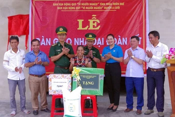 Đại tá Đặng Ngọc Hiệu, Chủ nhiệm Chính trị Bộ đội Biên phòng tỉnh và đại diện các đơn vị tặng quà cho đại diện gia đình ông Cu Doan, trú tại thôn Pi Ây 1, xã Quảng Nhâm.