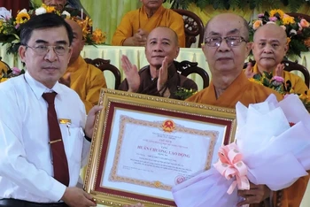 Trưởng Ban Dân vận Tỉnh ủy BếnTre Bùi Văn Bia trao Huân chương Lao động hạng Ba, trao hoa chúc mừng Hòa thượng Thích Nhựt Tấn.