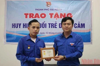 Trao Huy hiệu “Tuổi trẻ dũng cảm” cho anh Phan Thanh Phú.